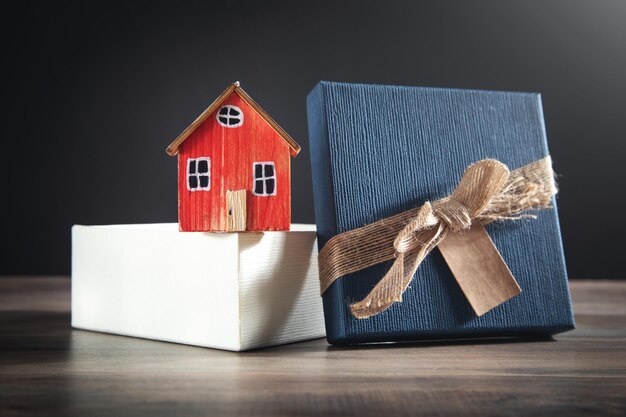 Gift box and house model on the wooden table