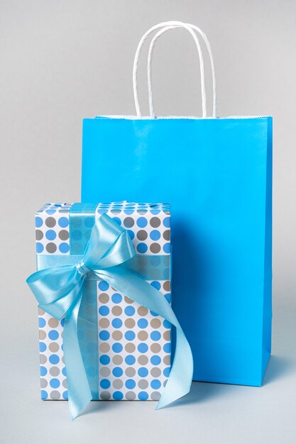 Фото Подарочная коробка из черной бумаги и синего банта с эко-бумажным пакетом. набор поздравлений