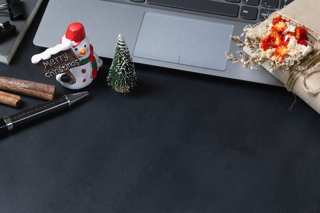 Gift box on a laptop and snowman toy 