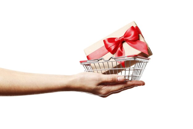 Confezione regalo si trova in un carrello in mano isolato su uno sfondo bianco.