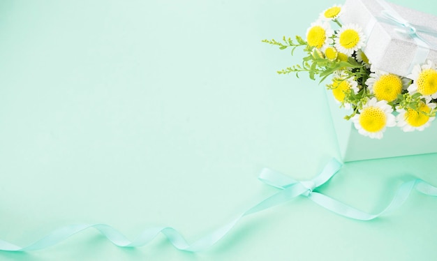 Gift box in mint color with white flowers inside