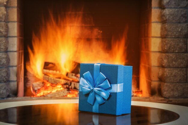 Gift box near cozy fireplace in country house