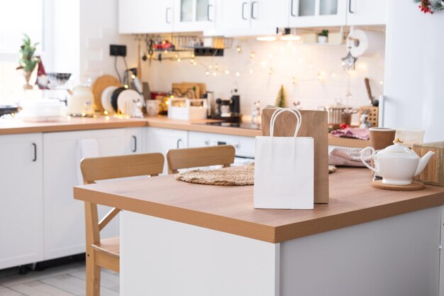 La confezione regalo e i pacchetti sono sul tavolo della cucina decorato per il natale presente e i pasti pronti vengono consegnati e preparati per il nuovo anno