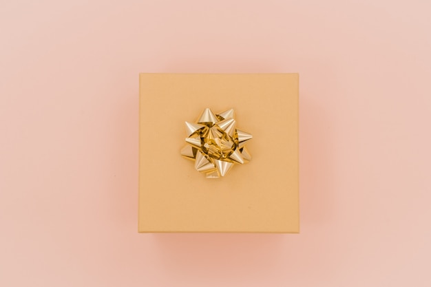 Gift box present with golden bow, top view