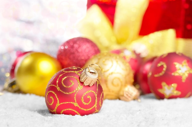 Gift box and red christmas balls in the snow