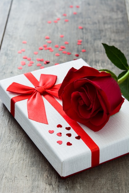 Gift box and red rose on wooden Valentines concept