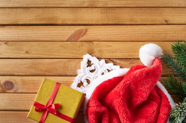 Gift box,santa hat,fir branch on wooden background. New year and christmas concept Copy space