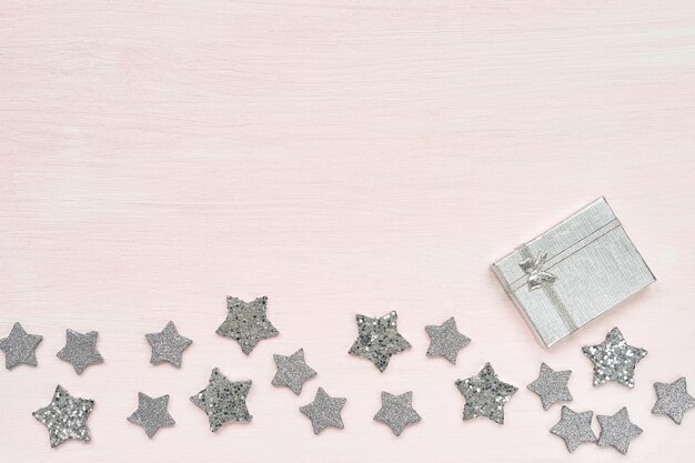 Gift box and silver decoration on pink.