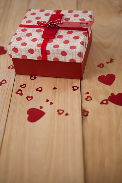 Gift box surrounded with red heart decoration