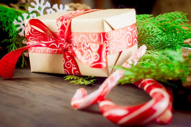 Gift box tied with a red ribbon , fir branches,candy 