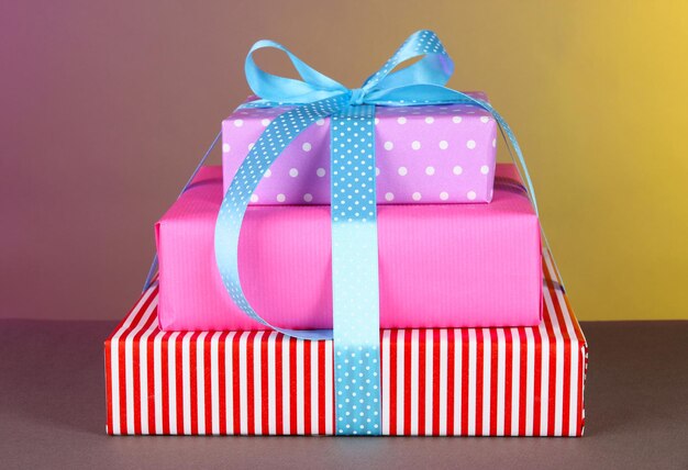 Подарочная коробка, перевязанная лентой на цветном фоне