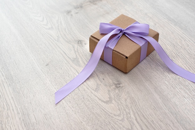 Gift box tied with a satin purple ribbon.