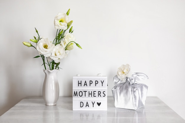 Confezione regalo trendy avvolta in tessuto di seta con tecnica furoshiki, light box con scritta happy mother's day