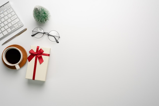 Gift box on a white desk. Christmas or New Year gift giving concept.