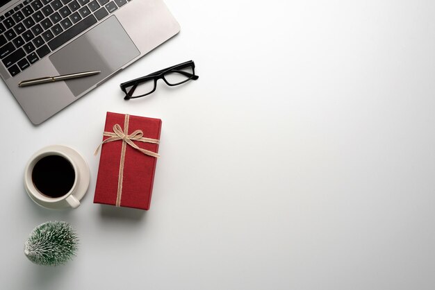 Gift box on a white desk. Christmas or New Year gift giving concept.