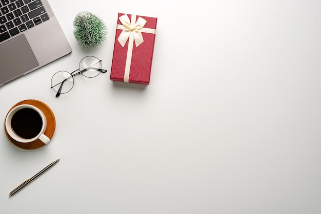 Gift box on a white desk. Christmas or New Year gift giving concept.