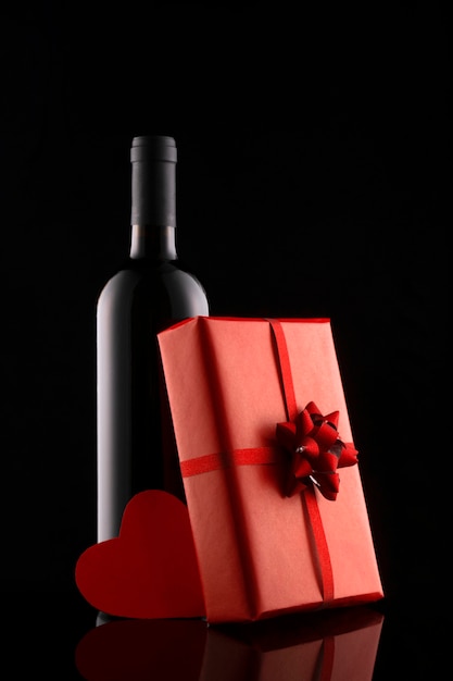 Gift box and wine bottle isolated on black