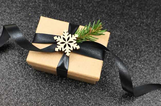 黒のリボンとクリスマスの装飾が施されたギフトボックス