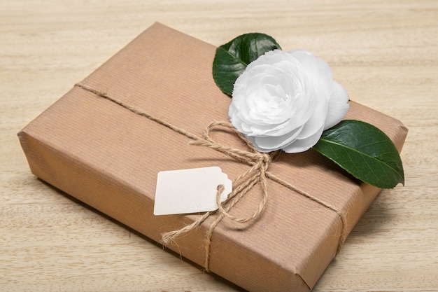  Gift box with blank label and flower. Celebration or present concept