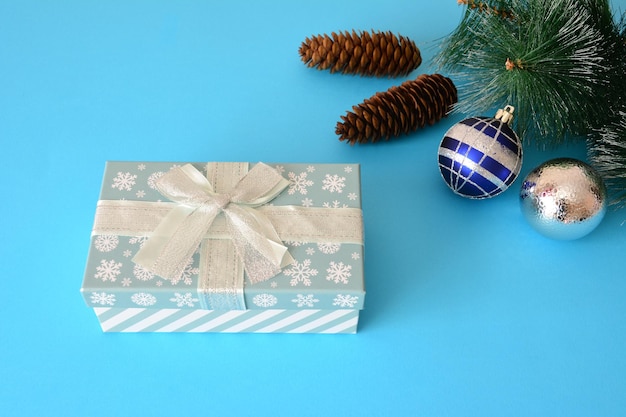 gift box with blue and silver christmas spheres and pine cones