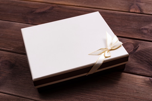 Gift box with bow for anniversary or christmas on a dark wooden table