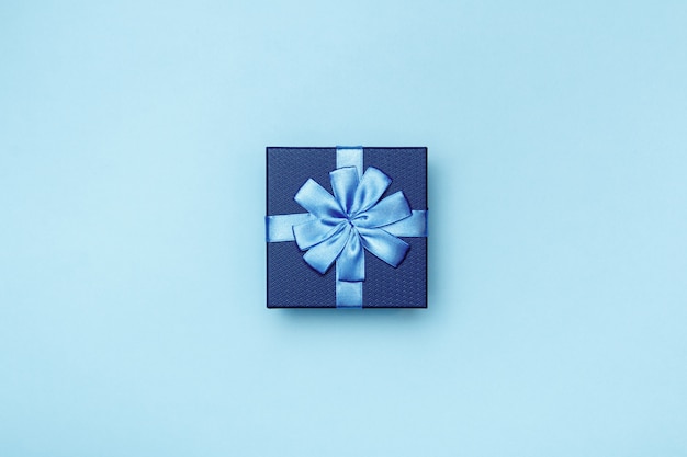 Фото Подарочная коробка с бантом на синем фоне