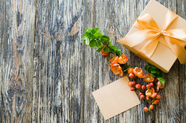 Gift box with bow ribbon, blank tag and delicate flowering branch.