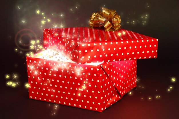 Gift box with bright light on it on dark grey background