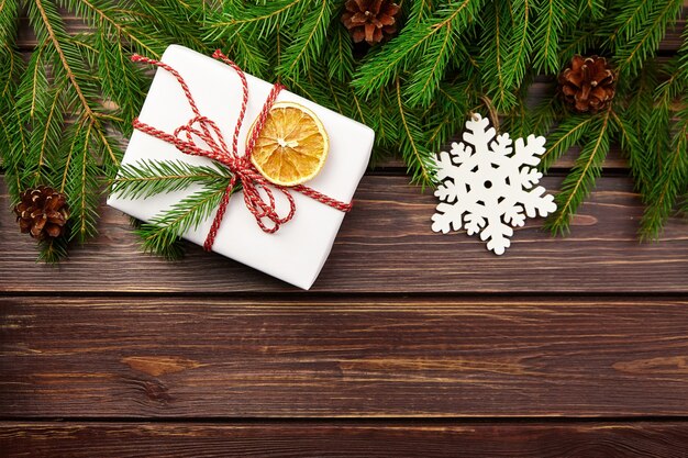 Gift box with fir tree branches and christmas decorations