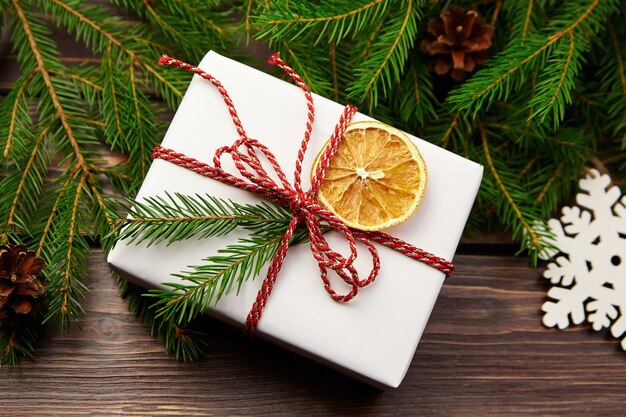 Gift box with fir tree branches and christmas decorations