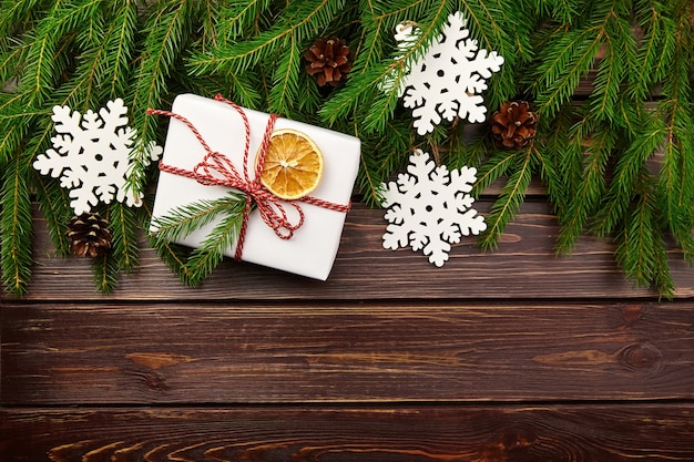 Gift box with fir tree branches and christmas decorations