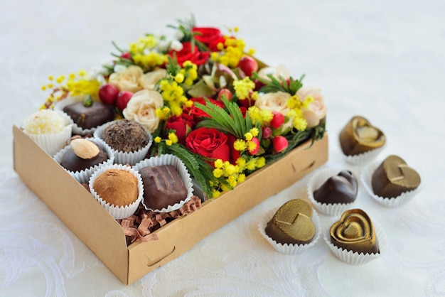 Gift box with flowers and candies made of chocolate