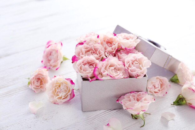 Gift box with flowers on wooden table