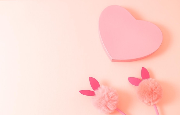 Gift box with a heart and a bunny handle on a naturally beige background