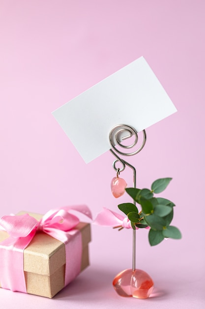 Foto confezione regalo con un fiocco rosa e una carta vuota.