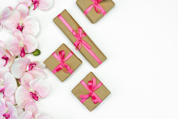 Gift box with a pink ribbon and orchid flowers