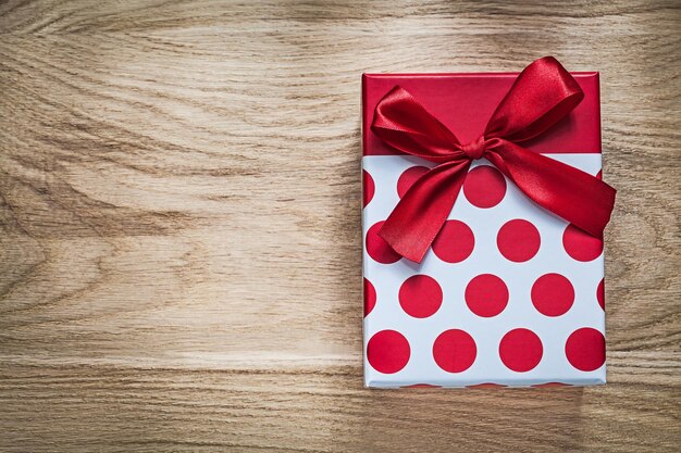 Gift box with present on wooden board holidays concept