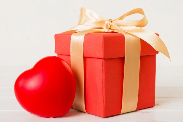 사진 은색 배경에 빨간색 활과 빨간색 심장을 가진 선물 상자 전망 평평한 배치