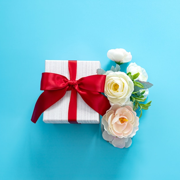 Photo gift box with red bow on a blue surface