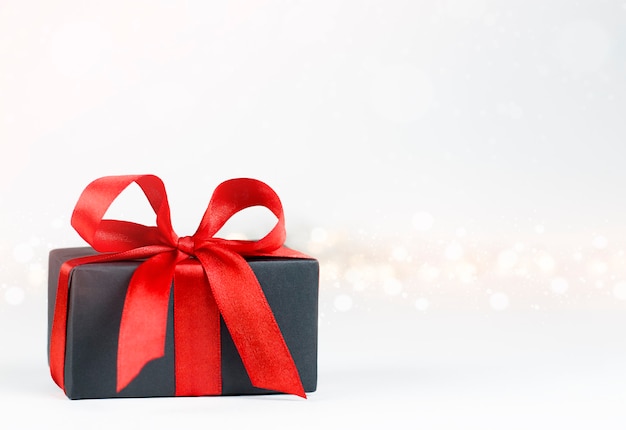 Gift box with red bow on defocus lights wall