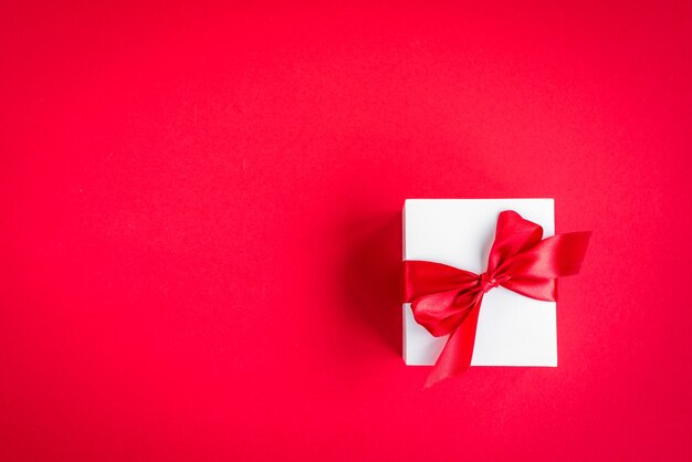 Gift box with red bow on red.