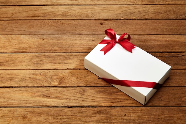 gift box with red bow on wood 