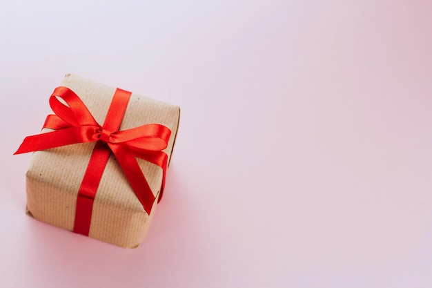 gift box with a red bow wrapped in brown paper copy space. Valentine's Day Gift