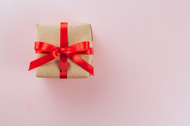 gift box with a red bow wrapped in brown paper copy space. Valentine's Day Gift