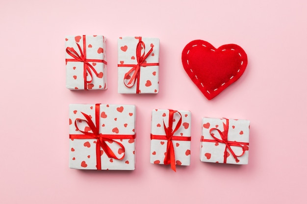 Gift box with red hearts on coral background. top view with copy space