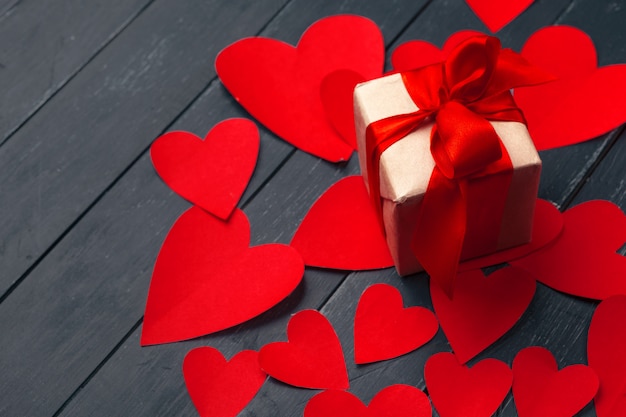 Gift box with red hearts on wooden surface table