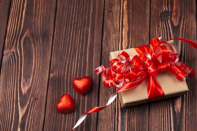 Подарочная коробка с красными сердцами на деревянный стол