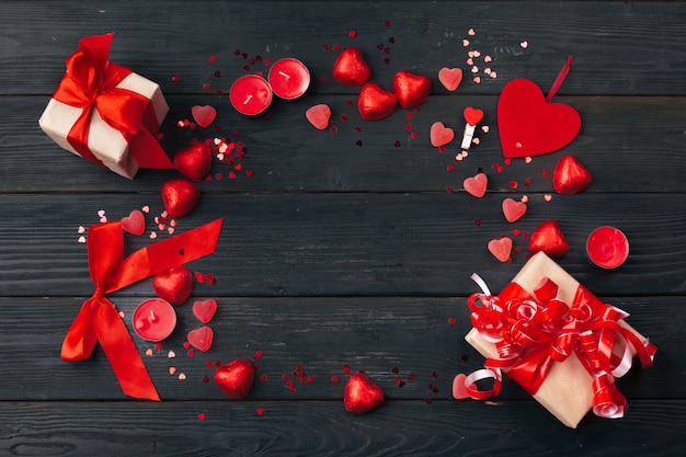 Gift box with red hearts on wooden table