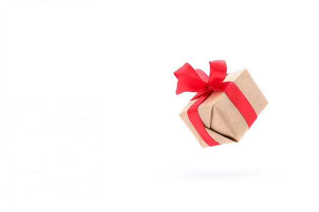 Gift box with red ribbon isolated in air on white.