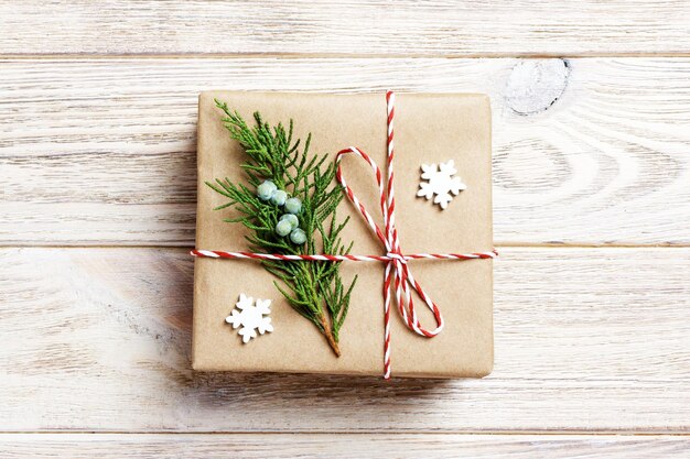 Gift box with red ribbon over white wooden background